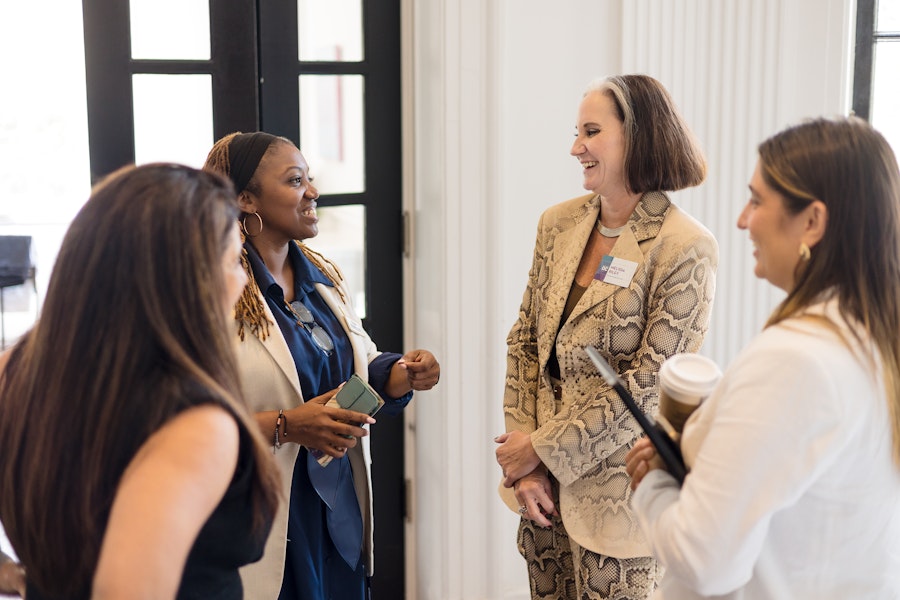 A professional and engaging conversation among a group of women in a bright and welcoming setting.