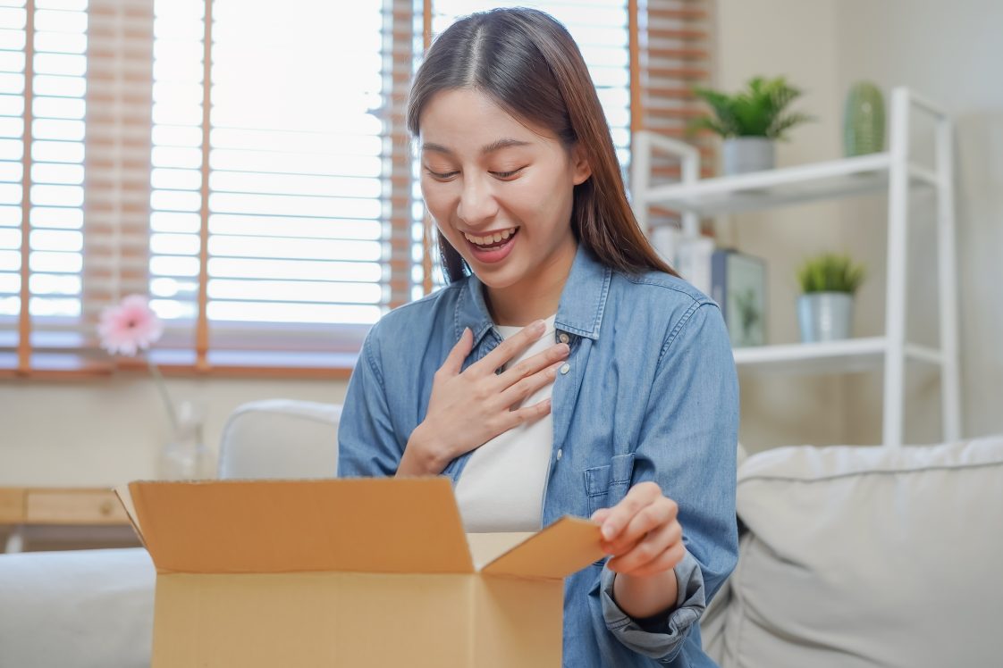 happy woman unboxing a package