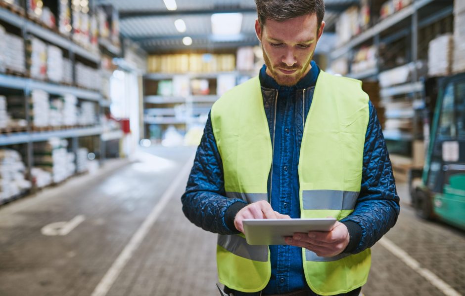 warehouse worker looking at tablet for order management