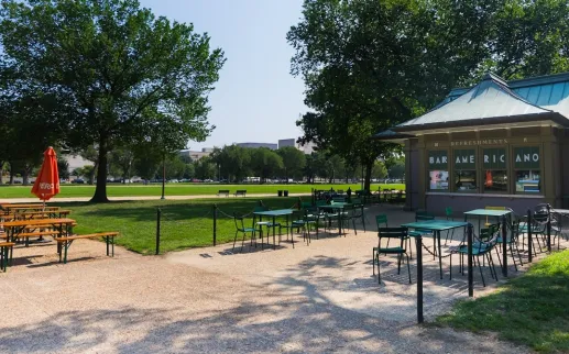 Outdoor tables and umbrellas surround the Bar Americano refreshment kiosk on the National Mall.
