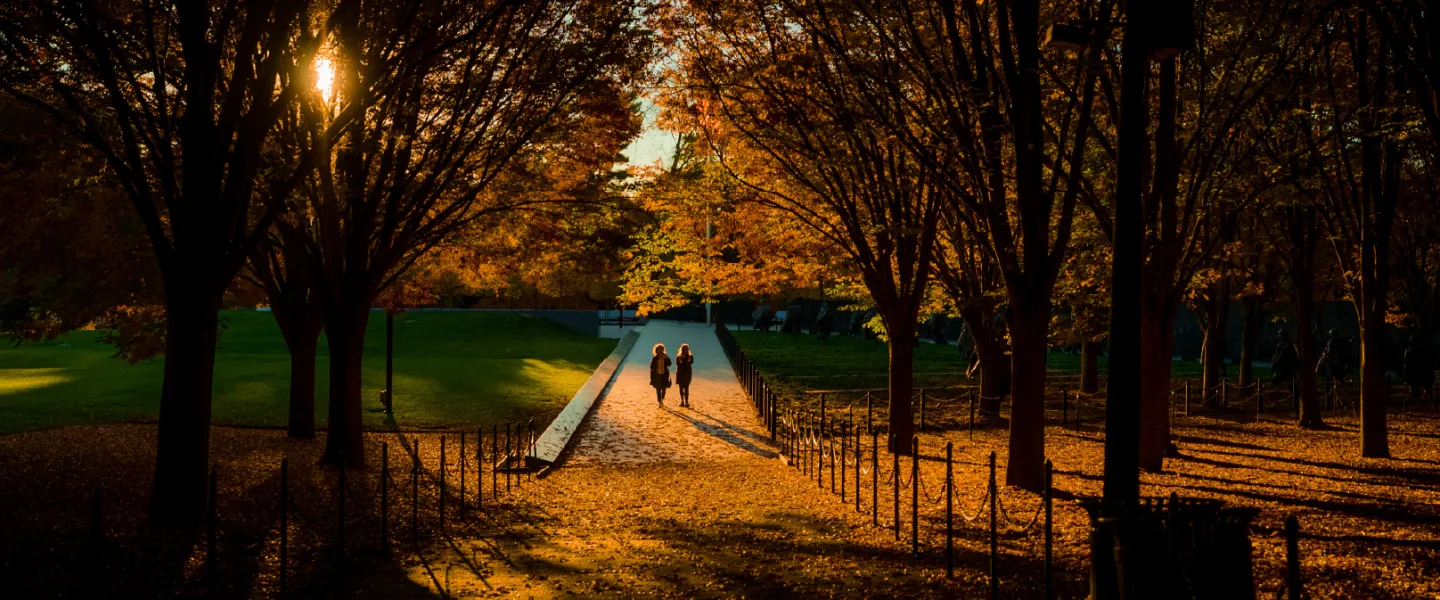 Two people walking at the Vietnam Veterans Memorial in Fall