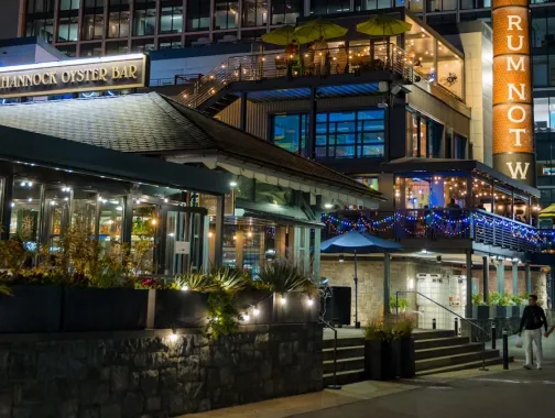Businesses are lit up and busy at night along The Wharf in DC. 