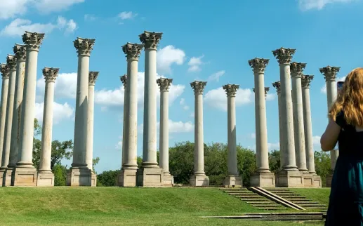 One person takes the photo of another with the Capitol Columns at the U.S. National Arboretum.